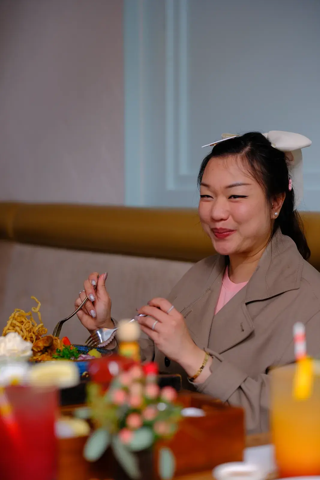 A smiling guest holding her cutlery over a brunch plate
