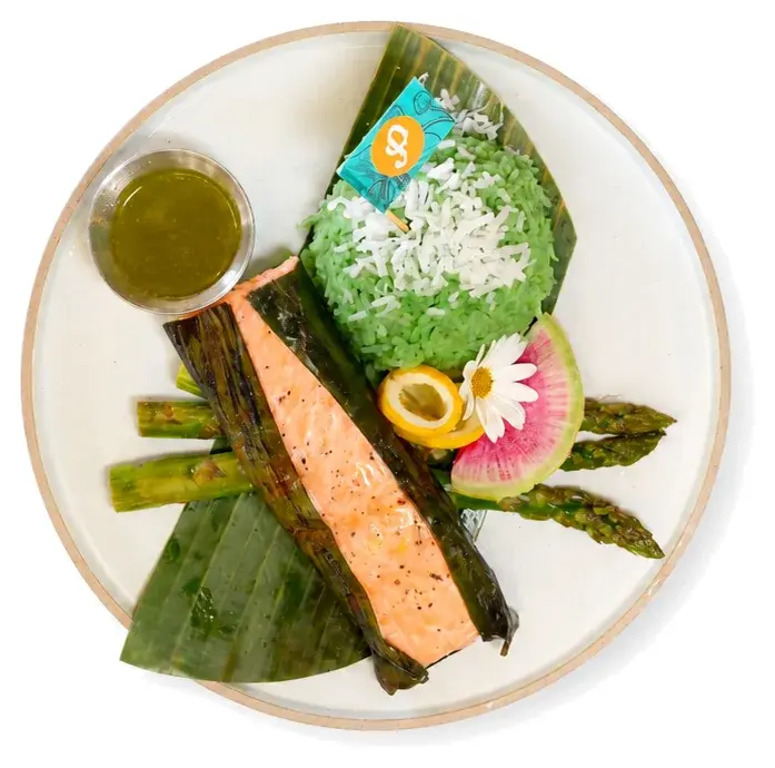 Grilled salmon with asparagus and rice wrapped in a banana leaf